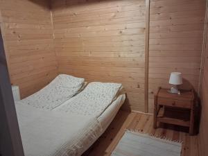 a bedroom with two beds and a table with a lamp at Domek za lasem in Laskowa