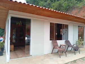 a house with two chairs and a table on a patio at Sítio em São Bonifácio in Alto Rio Bravo