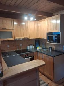a kitchen with wooden cabinets and a counter top at Domek za lasem in Laskowa +7 photos