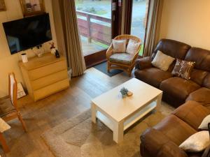 a living room with a couch and a coffee table at Skye Lodge in Tighnabruaich