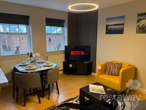 a living room with a table and a tv at restaway at Hamilton in Doncaster