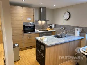 a kitchen with a counter and a clock on the wall at restaway at Hamilton in Doncaster
