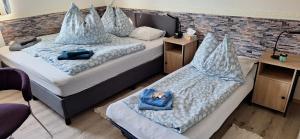 two beds in a room with blue pillows at Haus Hoogendam in Leoben
