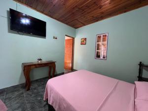 a bedroom with a bed and a tv on the wall at Punto Clave in Posadas