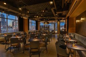 a restaurant with tables and chairs and large windows at Aloft by Marriott Providence Downtown in Providence