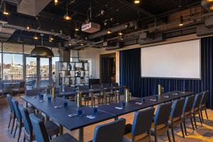 a long table in a room with chairs and a projection screen at Aloft by Marriott Providence Downtown in Providence