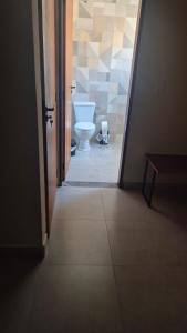 a hallway to a bathroom with a toilet in it at Chácara Anna Julia in Piedade +5 photos