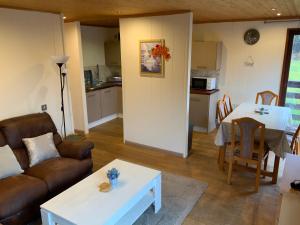 a living room with a couch and a table at Skye Lodge in Tighnabruaich