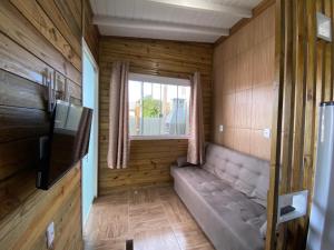 a small room with a couch and a window at Conforto na praia 2 Quartos com Ar Até 6 Pessoas in Imbituba