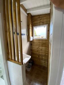 a small bathroom with a tub and a window at Conforto na praia 2 Quartos com Ar Até 6 Pessoas in Imbituba +6 photos