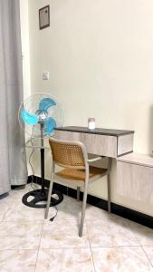 a desk with a chair and a fan in a room at Muyenga Studio Apartments in Kampala