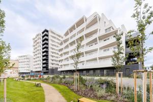 an apartment building with a garden in front of it at Calmora apartment Optická WiFi Klimatizace Balkon Nespresso in Komárov