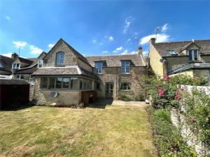 a large brick house with a yard at Traditional Cotswold escape with garden and fireplace in Cheltenham