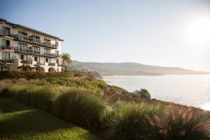 a building on a hill next to a body of water at Terranea Resort in Rancho Palos Verdes