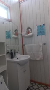 a white bathroom with a sink and a toilet at Cabaña El Quijote in Valdivia
