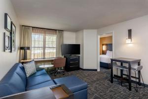 a hotel room with a couch and a room with a bed at Residence Inn Worcester in Worcester