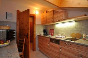 a kitchen with wooden cabinets and a counter top at Landhaus Reiser in Grainau +11 photos