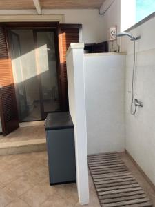 a bathroom with a shower and a trash can at Solemar Salento in Marittima