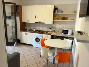 a kitchen with a table and orange chairs at Solemar Salento in Marittima +14 photos