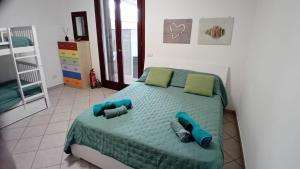 a bedroom with a bed with green sheets and green pillows at Solemar Salento in Marittima