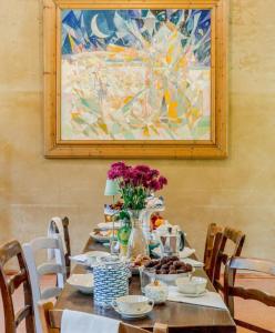 a table with a vase of flowers on it at La Locanda di Diogene in Case Reggiani