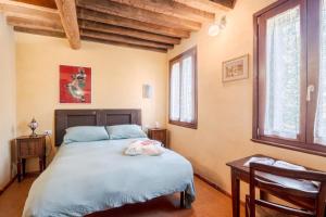 a bedroom with a bed and two windows at La Locanda di Diogene in Case Reggiani