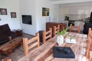 a living room with a wooden table and a kitchen at Ferienhaus TRAUM AM SEE mit Sauna und Whirlpool in Zislow +31 photos