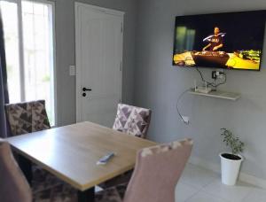 a dining room with a table and a tv on the wall at Complejo Los Olivos in Ciudad Lujan de Cuyo