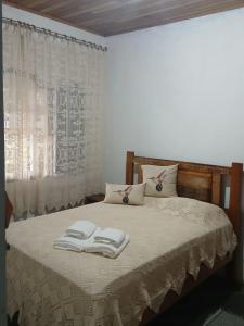 a bedroom with a bed with two towels on it at Recantos das Avencas in Água Boa