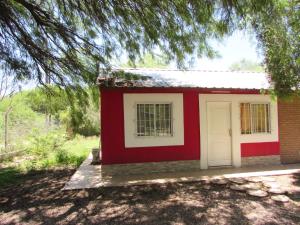 a red and white building with a white door at Complejo Kallpa in Santiago del Estero