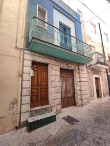a building with a balcony and a wooden door at U Paradis - Appartamento - Vicino Bari in Valenzano