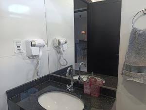 a bathroom with a sink and a phone on the wall at Casa Gourmet Próx Marco Argentina Paraguai e Centro in Foz do Iguaçu