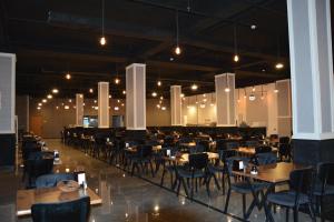 a dining room with tables and chairs and lights at MyFlower 3 Hotel in Erbil