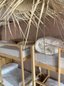 a room with a bunk bed and two chairs at Tayri Surf House Aourir in Agadir