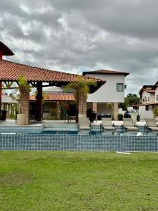 a house with a pool with chairs and a gazebo at Casa Amaré Barreirinhas in Barreirinhas