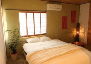 a bedroom with a large bed with a window at 京都 大阪アクセス良好の和モダン民泊 静かで快適な宿泊施設です 京阪本線楠葉駅から徒歩圏内 急行特急停車駅で京都へ約30分 大阪へ約40分とアクセス良好です in Hirakata