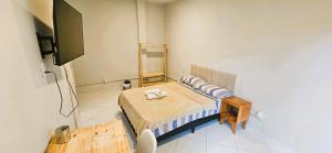a small room with a bed and a tv at Vila Boulevard Aconchegante in Manaus