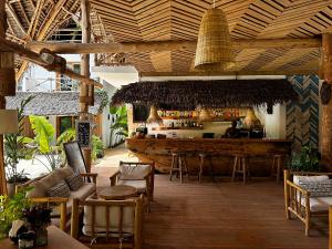 a bar in a restaurant with a wooden ceiling at Boutique Villa Unaweza in Matemwe