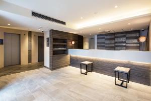 a lobby with a counter and two stools at HOTEL MYSTAYS Gotanda in Tokyo