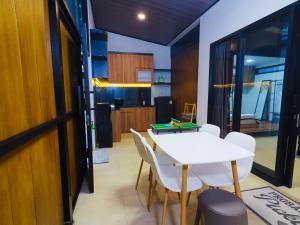 a dining room with a white table and chairs at Pickle n Pod villa in Solo with pickle court near mall in Grogol