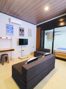 a living room with a couch and a bed at Pickle n Pod villa in Solo with pickle court near mall in Grogol