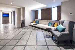 a waiting room with a couch and two chairs at HOTEL MYSTAYS Gotanda in Tokyo