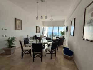 a dining room and living room with a table and chairs at Departamento Playa Punta Diamante in Acapulco