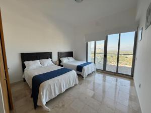 a bedroom with two beds and a large window at Departamento Playa Punta Diamante in Acapulco +19 photos