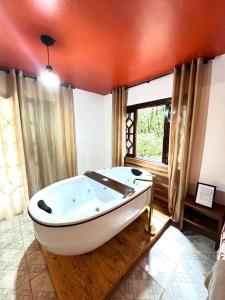 a white bath tub in a room with a window at Villaggio Farnese in Campos do Jordão