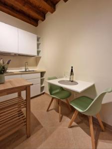 a kitchen with a table and chairs and a bottle of wine at HolidHome - Soave Borgo Suite - Mini appartamento di charme nelle mura medievali in Soave