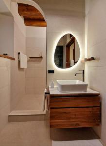 a bathroom with a sink and a tub and a mirror at HolidHome - Soave Borgo Suite - Mini appartamento di charme nelle mura medievali in Soave +11 photos