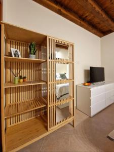 a room with a book shelf and a television at HolidHome - Soave Borgo Suite - Mini appartamento di charme nelle mura medievali in Soave