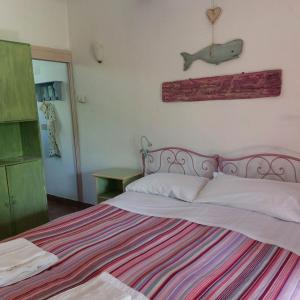 a bedroom with a large bed with a striped blanket at Orto delle Fate in Marta
