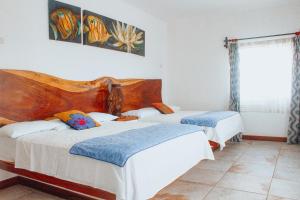 a bedroom with two beds and a window at Dos Mundos Pacific Resort in Monterrico +44 photos